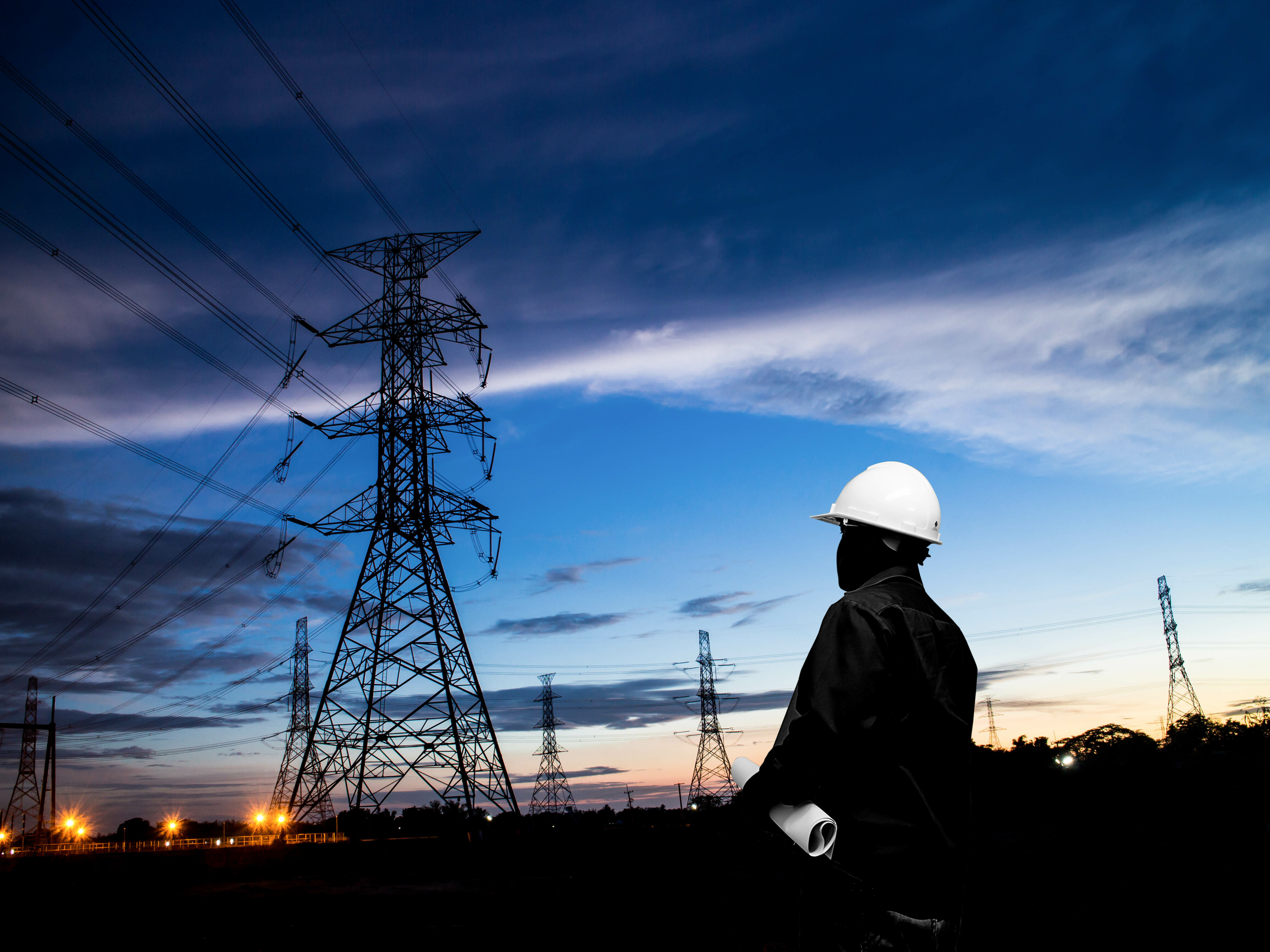 silhouette of engineers standing at electricity station